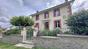 a brick house with a fence in front of it at Boissac in Le Vigen