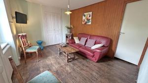 a living room with a red leather couch and a table at Boissac in Le Vigen