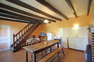 a kitchen with a wooden table and a staircase at Boissac in Le Vigen +18 photos