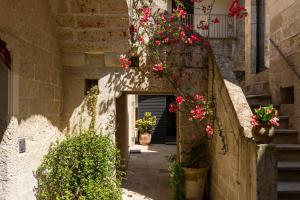 an alley with flowers on the side of a building at Ricci Rooms in Maglie +73 photos