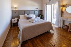 a bedroom with a large bed with a wooden floor at The White Chalet Boutique in Moshav Ramot