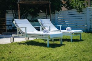 two lounge chairs sitting on the grass in the yard at The White Chalet Boutique in Moshav Ramot