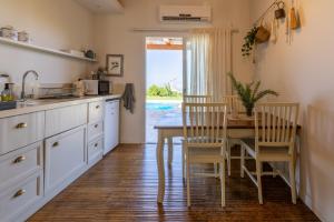 a kitchen with a table and chairs and a dining room at The White Chalet Boutique in Moshav Ramot