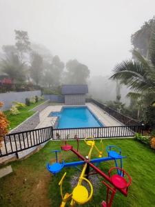 a swimming pool with a toy playground next to it at Wild Nest Resort, Wayanad in Meppādi