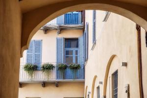 a building with blue shutters and potted plants on a balcony at Vittorio Emanuele Apartment - Downtown Como in Como