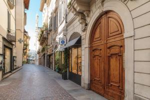 a building with a large wooden door on a street at Vittorio Emanuele Apartment - Downtown Como in Como