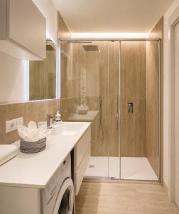 a bathroom with a shower and a washing machine at Vittorio Emanuele Apartment - Downtown Como in Como