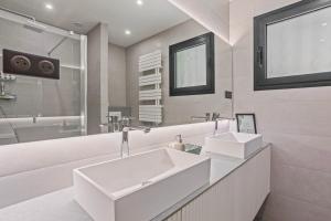 a white bathroom with a sink and a mirror at Les Oliviers De Lunéa in Fayence +23 photos