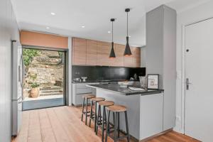 a kitchen with a counter and stools in it at Les Oliviers De Lunéa in Fayence