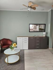 a living room with a ceiling fan and a table at Viesu nams AMRAI in Ventspils