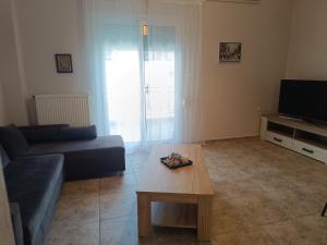 a living room with a couch and a coffee table at Summer apartment in Nea Peramos