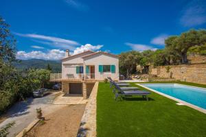 a villa with a swimming pool and a house at Les Oliviers De Lunéa in Fayence