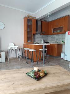 a kitchen with wooden cabinets and a plate of food on a table at Summer apartment in Nea Peramos