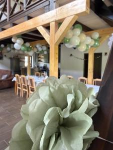 a table with a bunch of green and white balloons at Csodaszarvas Erdeiház in Borzont