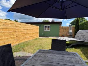 a table and chairs with an umbrella in a backyard at Strandoase in Grömitz