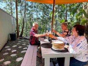 a group of people sitting at a table with drinks at Kholiwe 1 - 4 sleeper glamping in a forest in Port Edward