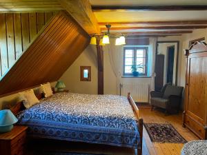 a bedroom with a bed and a chair in a room at Skansen Gottwaldówka in Kąty Bystrzyckie