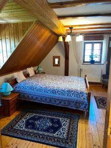 a bedroom with a bed with a wooden ceiling at Skansen Gottwaldówka in Kąty Bystrzyckie +5 photos
