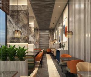 a restaurant with orange chairs and tables in a lobby at Goldfinch Panjim Goa in Old Goa