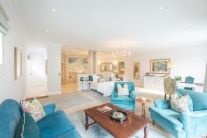 a living room with blue furniture and a bed at Last Word Constantia in Cape Town