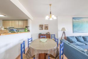 a living room with a table and a blue couch at Port Pals B202 in Pals