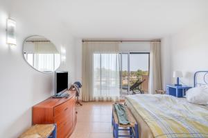 a bedroom with a bed and a tv and a mirror at Port Pals B202 in Pals +29 photos