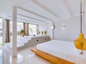 a white bedroom with a large bed and a tub at Villa Monica with Private Pool and Jacuzzi in Quarteira