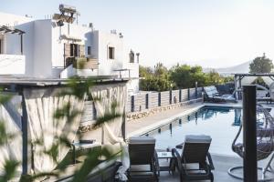 ein Swimmingpool mit Stühlen neben einem Haus in der Unterkunft Villa Parisi Naxos Deluxe in Naxos Chora