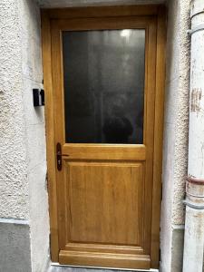 a wooden door with a window on a building at La maison du Quart - Maison de village in Sommières +2 photos