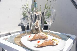 a plate of food on a table with wine glasses at Palazzo Sorge - Sicilian Charm in Balestrate
