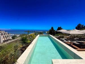 a swimming pool with a view of the ocean at Moon & Sun Funchal in Funchal