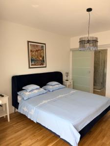 a bedroom with a large bed with a chandelier at Zimmer Room Trogir Kastela Split in Kaštela