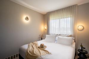 ein Schlafzimmer mit einem weißen Bett, auf dem ein Hut liegt in der Unterkunft Tzuba Hotel in Ẕova + 63 Fotos