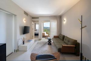 ein Wohnzimmer mit Sofa und Fernseher in der Unterkunft Tzuba Hotel in Ẕova