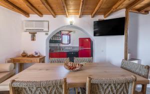 a dining room with a wooden table and a red refrigerator at Marketos Traditional Windmill in Tripiti