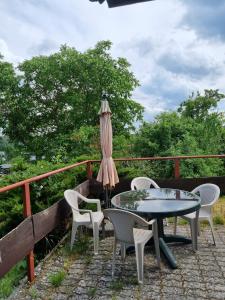 a patio with a table and chairs and an umbrella at Kłączyn in Kłaczno