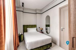 a bedroom with a white bed in a room at TriplyRooms Collection - Roma Prassede in Rome