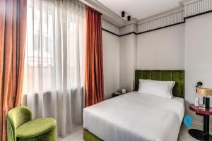 a bedroom with a bed and a chair and a window at TriplyRooms Collection - Roma Prassede in Rome +8 photos
