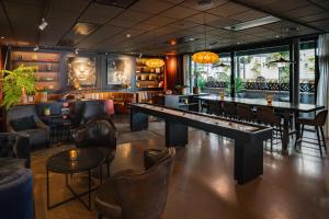 a restaurant with a table and chairs and a bar at Scandic Arvika in Arvika