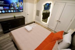 a bedroom with a bed and a tv on the wall at The Lovely Suite - 1BR close to NYC in Paterson