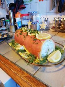 a fish on a plate on a counter with lemon slices at La Salamandre 66 in Saint-Génis +9 photos