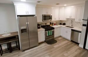 a kitchen with white cabinets and stainless steel appliances at The Lovely Suite - 1BR close to NYC in Paterson +14 photos