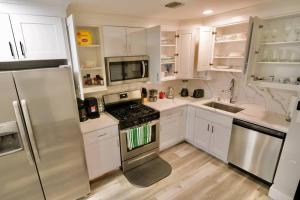 a white kitchen with a stove and a refrigerator at The Lovely Suite - 1BR close to NYC in Paterson