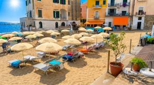 a group of umbrellas and chairs on a beach at Santa Maria Rooms in Santa Maria di Castellabate
