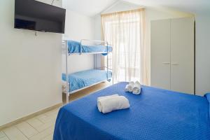 a bedroom with a blue bed with towels on it at Santa Maria Rooms in Santa Maria di Castellabate