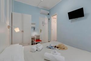 a room with a bed with towels and a television at Hotel Del Golfo in Laigueglia