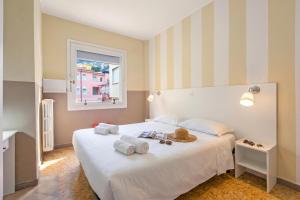 a bedroom with a white bed with towels and a window at Hotel Del Golfo in Laigueglia