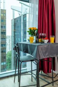 a table with a vase of flowers and wine glasses at Sky tower space in Katowice