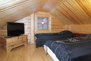 a room with two beds and a television in a cabin at Messilä Camping in Hollola