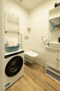 a washing machine in a bathroom with a toilet at Sky tower space in Katowice